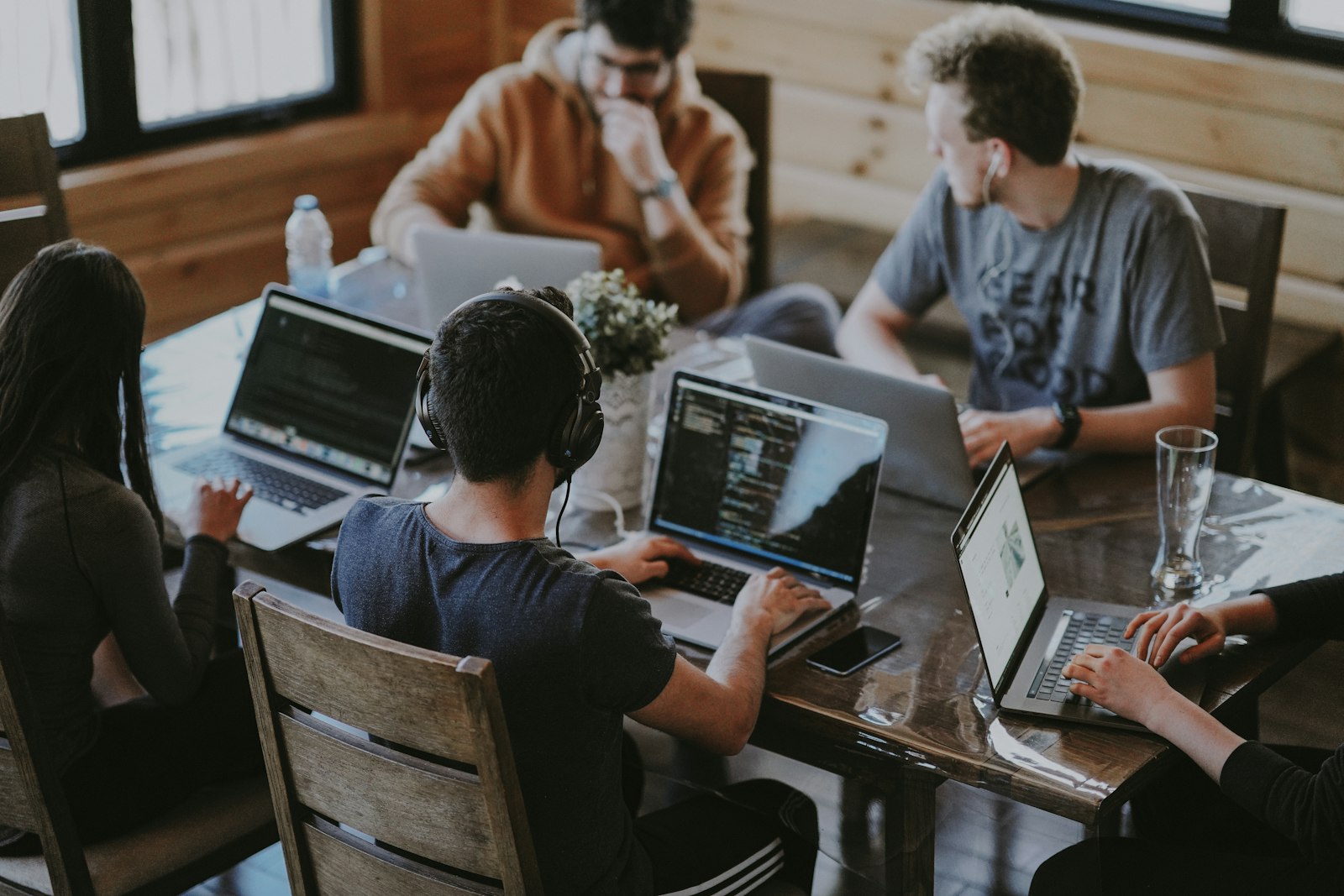 Marketing team collaborating on laptops around a table
